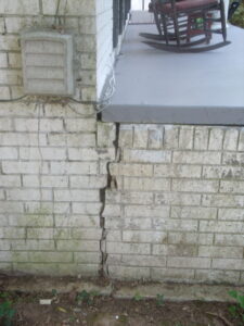 Large crack indicating settling of front porch away from house